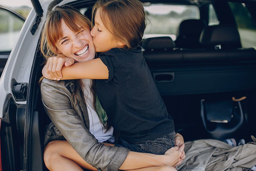 Personal Insurance - Happy Mother And Daughter Sitting In Back Trunk And Hugging